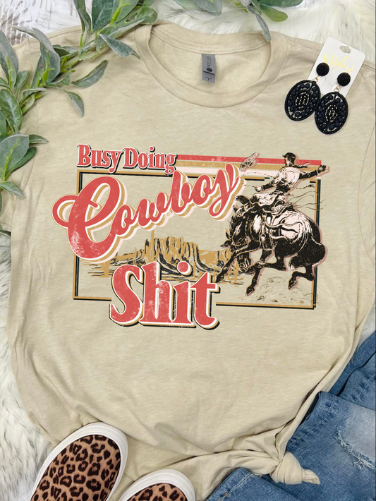 Busy Doing Cowboy Shit Tan Tee